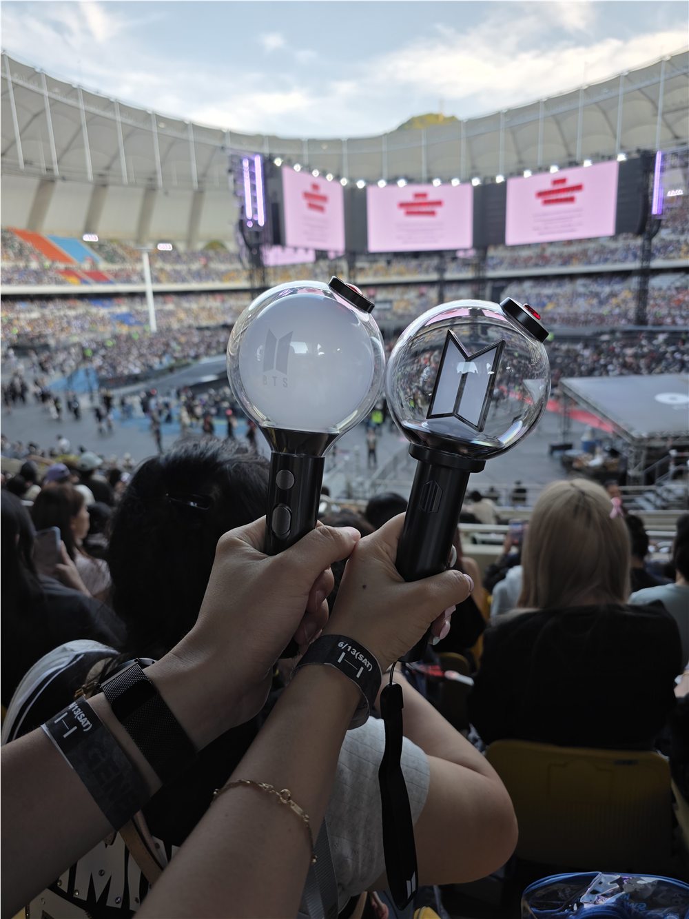 Two BTS light sticks held up before the concert at Busan Asiad Main Stadium