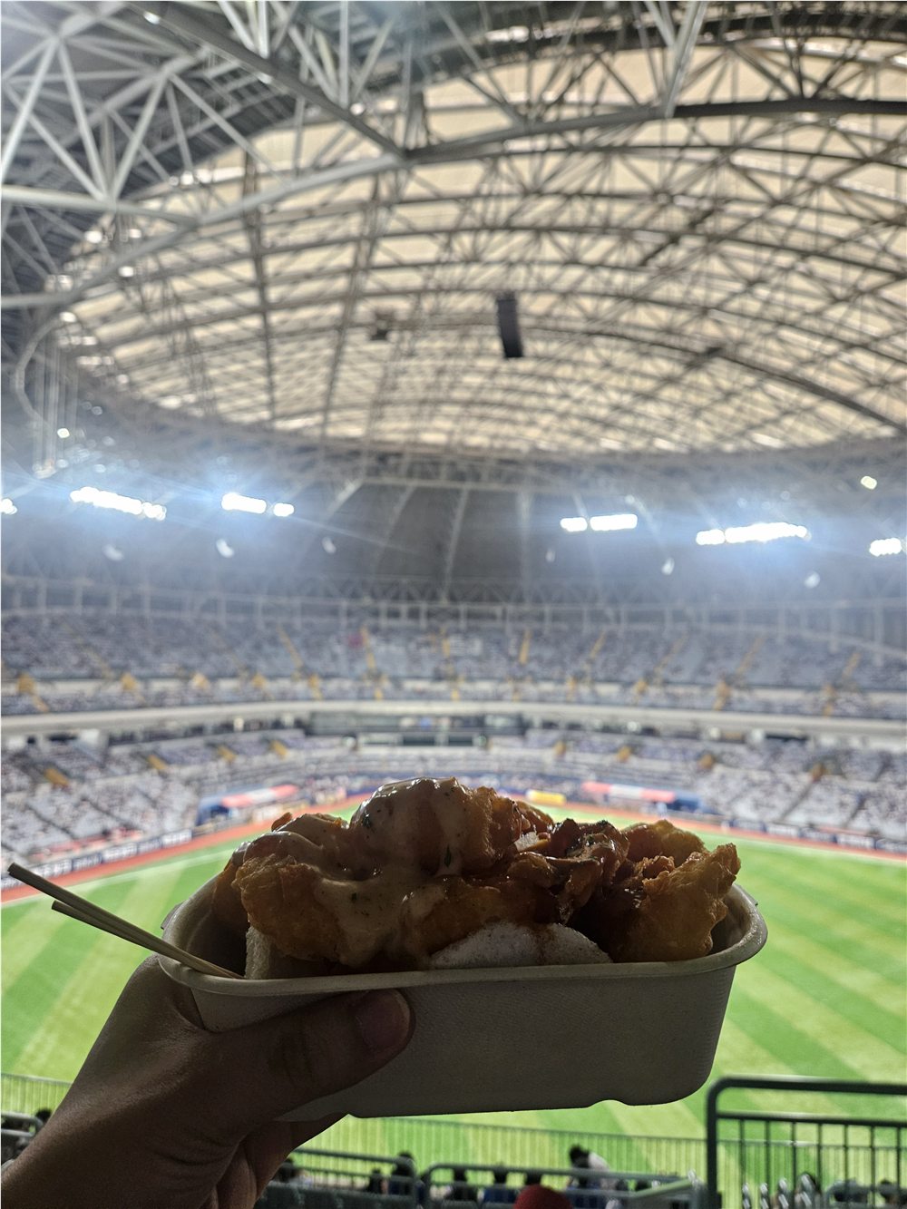 Cream shrimp in a takeaway tray with the Gocheok Sky Dome field behind it
