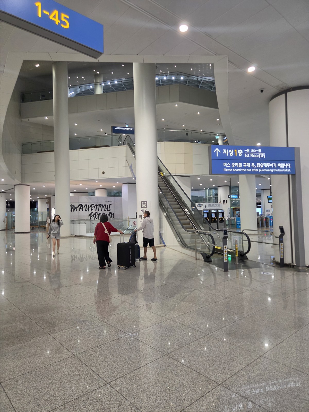 Bus terminal wayfinding signs and an escalator in the Terminal 2 transportation area